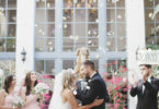 Couple staning at the alter with flowers