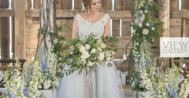 wedding ceremony with bride holding a rustic blue bouquet