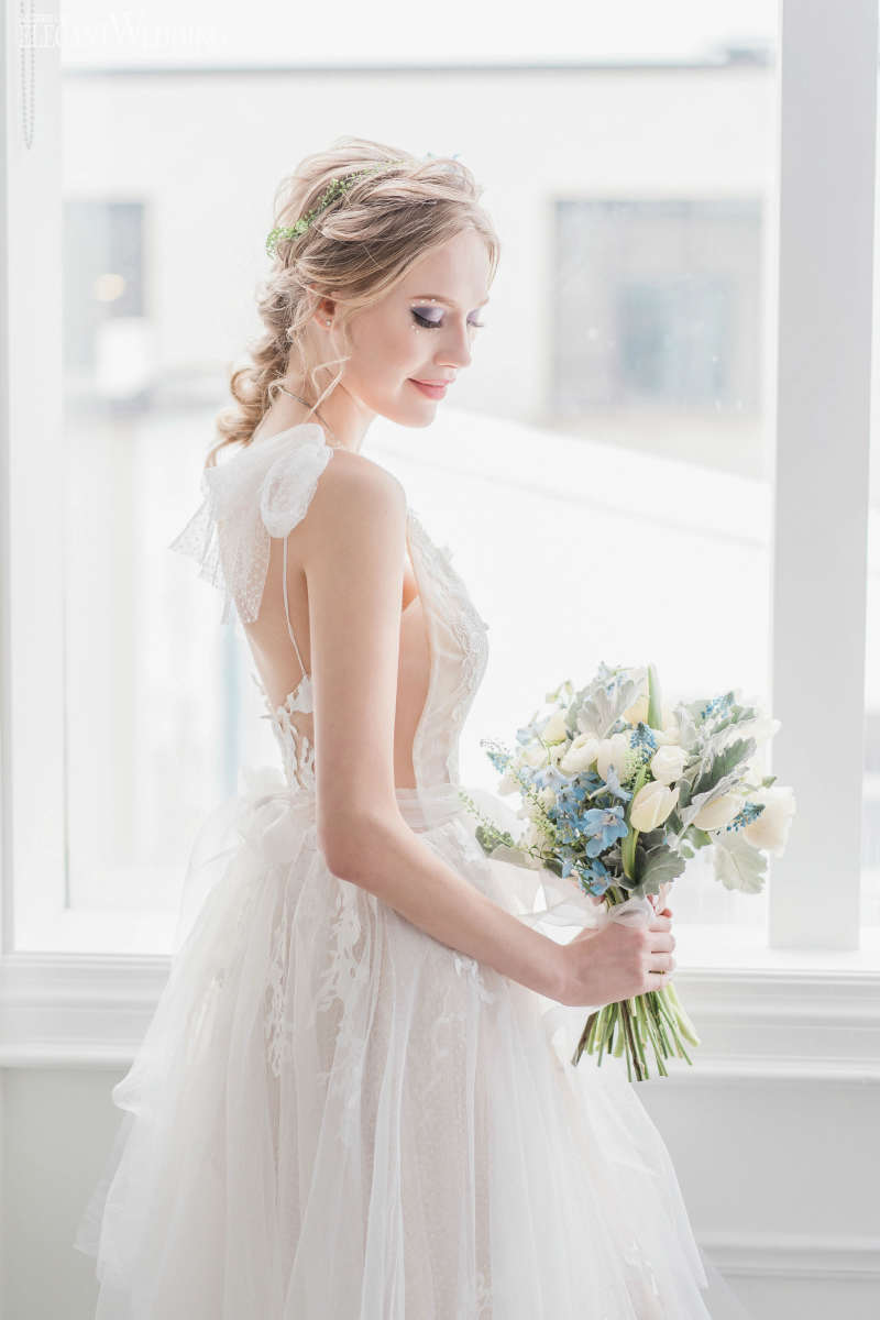 bride holding blue wedding bouquuet