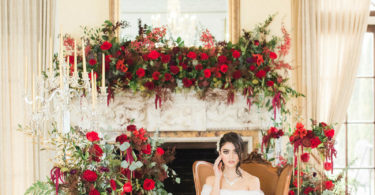 bride surrounded by red roses