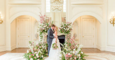 bride and groom in front of a fireplace