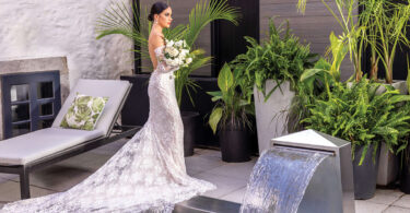 bride in a lace dress with a green and white bridal bouquet