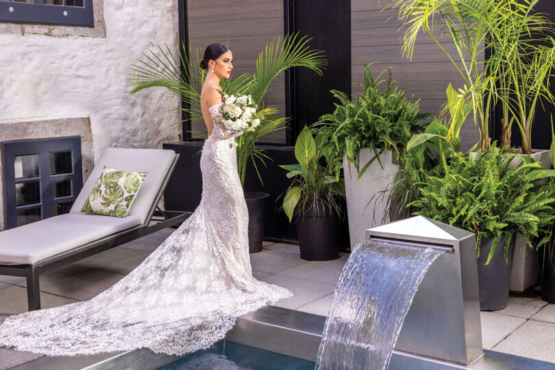 bride in a lace dress with a green and white bridal bouquet