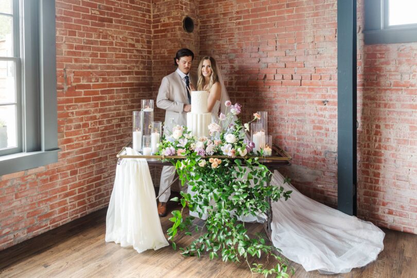 bride and groom with a white wedding cake